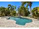 Secluded backyard oasis featuring a private pool surrounded by lush tropical landscaping and mature palm trees at 5909 Canton S St, St Petersburg, FL 33712