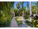 Backyard featuring a paver pathway to the shed surrounded by lush tropical landscaping at 5909 Canton S St, St Petersburg, FL 33712