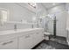 Modern bathroom featuring double sink vanity, large mirror, and glass-enclosed shower with rain shower head at 6911 N 19Th St, Tampa, FL 33610