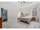 Spacious bedroom with tray ceiling, light wood floors, and a view to the bathroom at 6911 N 19Th St, Tampa, FL 33610