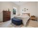 Bright bedroom with a window view, featuring a queen bed, dark wood dresser, and blue upholstered bench at 6911 N 19Th St, Tampa, FL 33610