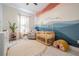 Charming Bedroom features a crib, comfortable chair, and colorful mural on the wall at 6911 N 19Th St, Tampa, FL 33610