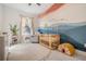 Charming Bedroom features a crib, comfortable chair, and colorful mural on the wall at 6911 N 19Th St, Tampa, FL 33610