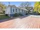 Charming two-story home featuring a spacious wooden deck, inviting front porch, and beautifully landscaped front yard at 6911 N 19Th St, Tampa, FL 33610