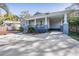 Home featuring a cozy porch, convenient carport, and well-maintained landscaping at 6911 N 19Th St, Tampa, FL 33610