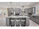 A well-equipped kitchen features stainless steel appliances, granite countertops, gray cabinets, and an island with barstool seating at 6911 N 19Th St, Tampa, FL 33610