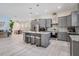 Modern kitchen with gray cabinetry, stainless steel appliances, a granite island, and open layout to dining area at 6911 N 19Th St, Tampa, FL 33610