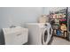 Well-lit laundry room featuring a Samsung washer and dryer and ample storage space on metal shelving at 6911 N 19Th St, Tampa, FL 33610