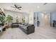 A living room features a large gray couch, modern flooring, natural lighting, and white paint at 6911 N 19Th St, Tampa, FL 33610