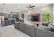 Open concept living area with a long gray couch, mounted television, and an open-concept kitchen at 6911 N 19Th St, Tampa, FL 33610