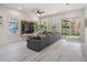 A cozy living room features a mounted television, large windows, sliding glass doors, and a huge gray couch at 6911 N 19Th St, Tampa, FL 33610