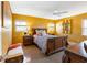 A traditionally styled bedroom with ornate wood furniture, complimented with a ceiling fan and a brightly painted yellow walls at 7320 Burlington N Ave, St Petersburg, FL 33710