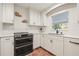 Bright kitchen featuring modern appliances, white cabinetry, and a view from the window at 8467 8Th N Way, St Petersburg, FL 33702