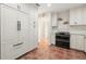 Well-lit kitchen with stainless steel appliances, white cabinets, and brick-look tile flooring at 8467 8Th N Way, St Petersburg, FL 33702