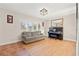 Sunlit living room with hardwood floors, a comfortable couch, a grand piano, and large shuttered windows at 8467 8Th N Way, St Petersburg, FL 33702