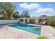 Backyard pool featuring sleek pavers, steps into the pool, and seating with a white privacy fence at 8467 8Th N Way, St Petersburg, FL 33702