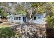 Landscaped backyard highlighting a large tree with platform and light blue house, creating a serene outdoor oasis at 930 40Th Ne Ave, St Petersburg, FL 33703