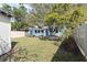 Expansive backyard with lush grass, wooden privacy fence, light blue house and a shed, providing ample space and seclusion at 930 40Th Ne Ave, St Petersburg, FL 33703
