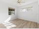 Bedroom features light wood floors, neutral walls, two large windows, and a ceiling fan at 930 40Th Ne Ave, St Petersburg, FL 33703