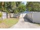 Long driveway along side of the light blue home, and a wooden privacy fence, offering convenient parking at 930 40Th Ne Ave, St Petersburg, FL 33703