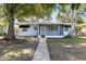 Charming single-story home featuring a screened porch, and a well-maintained front yard with mature trees at 930 40Th Ne Ave, St Petersburg, FL 33703