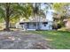 Charming single-story home with blue siding, a screened porch, and mature trees in the front yard at 930 40Th Ne Ave, St Petersburg, FL 33703