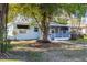 Quaint front exterior of light blue home, featuring a screened in porch, sidewalk and mature shade tree at 930 40Th Ne Ave, St Petersburg, FL 33703