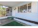 Covered porch showcasing light blue siding, a white door, and a view of the neighborhood at 930 40Th Ne Ave, St Petersburg, FL 33703