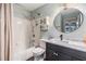 Cozy bathroom featuring a shower and tub combo, vanity with granite countertops, and a stylish mirror at 9481 Highland Oak Dr # 706, Tampa, FL 33647