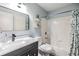 Bathroom with white tub and shower, marble countertop, black vanity, and shelf decor at 9481 Highland Oak Dr # 706, Tampa, FL 33647