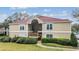 Inviting two-story condo building with a red roof, landscaped lawn, and sidewalk leading to the covered entryway at 9481 Highland Oak Dr # 706, Tampa, FL 33647