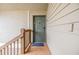 View of front door and porch area featuring wood railing and green door at 9481 Highland Oak Dr # 706, Tampa, FL 33647