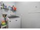 Bright laundry room with a white Maytag washing machine and shelving with cleaning supplies for convenient chore completion at 9481 Highland Oak Dr # 706, Tampa, FL 33647
