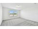 Cozy bedroom with natural light from two windows and modern gray carpet at 10537 Hidden Banks Gln, Parrish, FL 34219