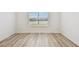 Bright bedroom with large window, neutral walls, and modern light gray floors at 10537 Hidden Banks Gln, Parrish, FL 34219