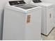 Modern laundry room with white, front-loading washer and dryer units at 10537 Hidden Banks Gln, Parrish, FL 34219