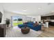 Bright living room featuring a lake view, a stylish blue couch, and an open layout to the modern kitchen at 10537 Hidden Banks Gln, Parrish, FL 34219