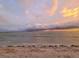 Tranquil ocean view with a beach in the foreground and a cloudy sunset sky above at 113 Michigan Blvd, Dunedin, FL 34698