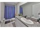 Well-lit bathroom featuring granite countertops, a sink, and a blue patterned shower curtain at 12928 Wildflower Meadow Dr, Riverview, FL 33579