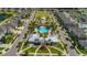 Aerial view of a community pool area featuring palm trees, a clubhouse, and well-kept grounds at 12928 Wildflower Meadow Dr, Riverview, FL 33579