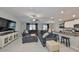 Open-concept living room featuring tile floors, modern furnishings, and seamless flow to the kitchen at 12928 Wildflower Meadow Dr, Riverview, FL 33579