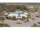 Aerial view of a spacious community pool area, clubhouse, tennis courts, and parking in a residential neighborhood at 13123 Rain Lily Dr, Riverview, FL 33579