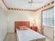 Cozy bedroom features a twin bed, floral accents, and a ceiling fan for added comfort at 1420 Oak Hill Dr # 102, Dunedin, FL 34698