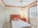 Cozy bedroom featuring floral accents, a ceiling fan, and bright natural light from the window at 1420 Oak Hill Dr # 102, Dunedin, FL 34698