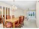A lovely dining area with a chandelier, complemented by a ceiling fan and a patio view at 1420 Oak Hill Dr # 102, Dunedin, FL 34698