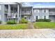 Two-story condo with balconies, lawn, and sidewalks at 1420 Oak Hill Dr # 102, Dunedin, FL 34698