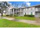 Exterior view of a well-maintained building with landscaped grounds and sidewalks at 1420 Oak Hill Dr # 102, Dunedin, FL 34698