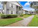The exterior features a multi-unit building with muted gray tones and well-kept landscaping at 1420 Oak Hill Dr # 102, Dunedin, FL 34698