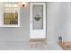 Inviting entryway featuring a bright white front door with decorative wreath and a sidelight window at 1420 Oak Hill Dr # 102, Dunedin, FL 34698