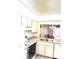 Bright kitchen features classic white cabinets and appliances, offering a cozy and functional space at 1420 Oak Hill Dr # 102, Dunedin, FL 34698